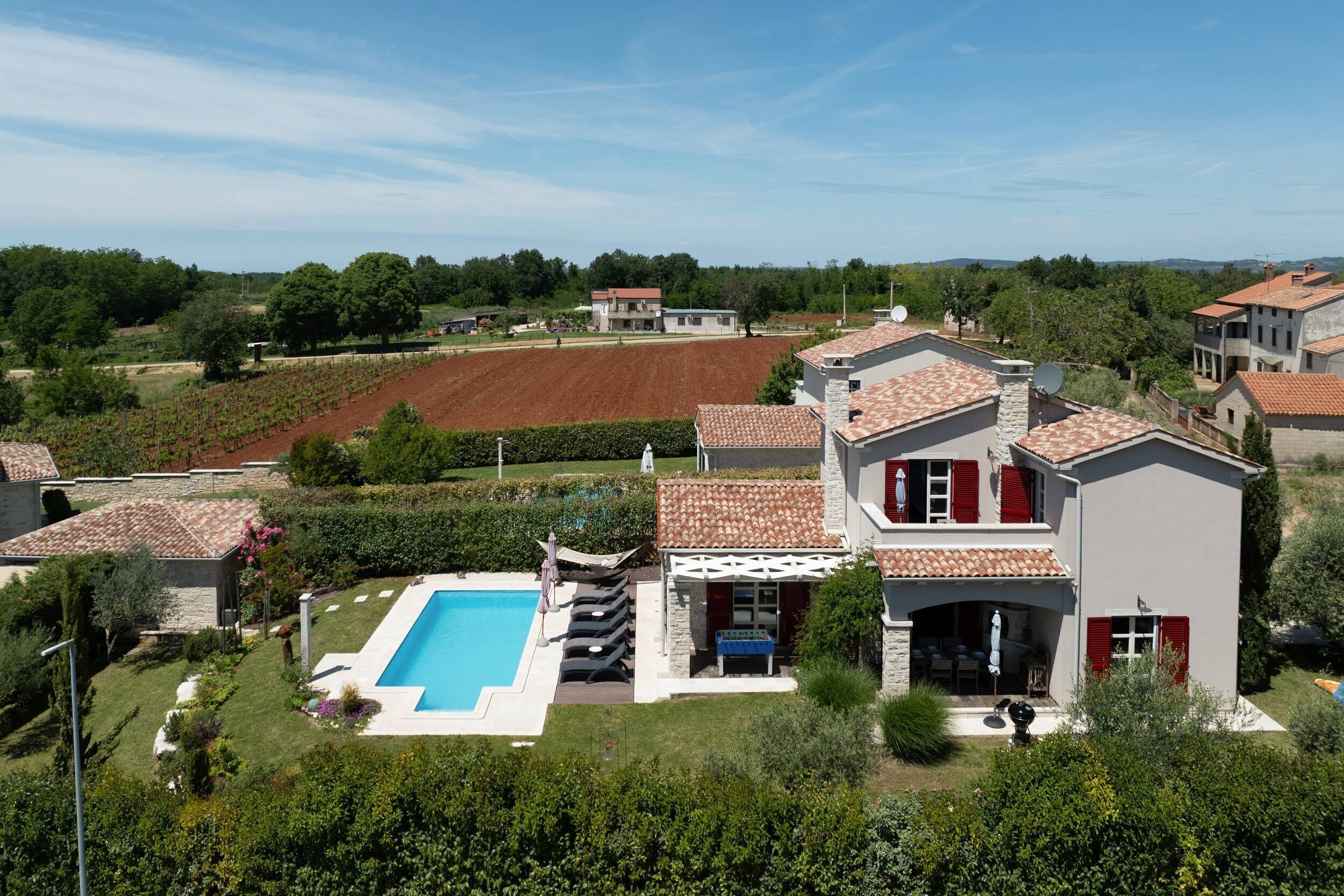 Une villa dotée d’une piscine, d’un jardin et offrant une vue sur la campagne environnante.