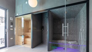 Une salle de bain moderne dotée d’une douche à parois de verre, d’un banc en bois et d’un porte-serviettes apparent.