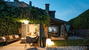 An outdoor patio area with a sofa, chairs, and a dining table.