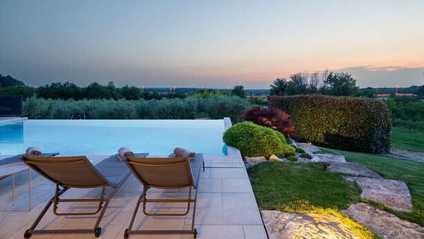 Un espace aménagé au bord de la piscine, avec des chaises longues et une vue sur le paysage.