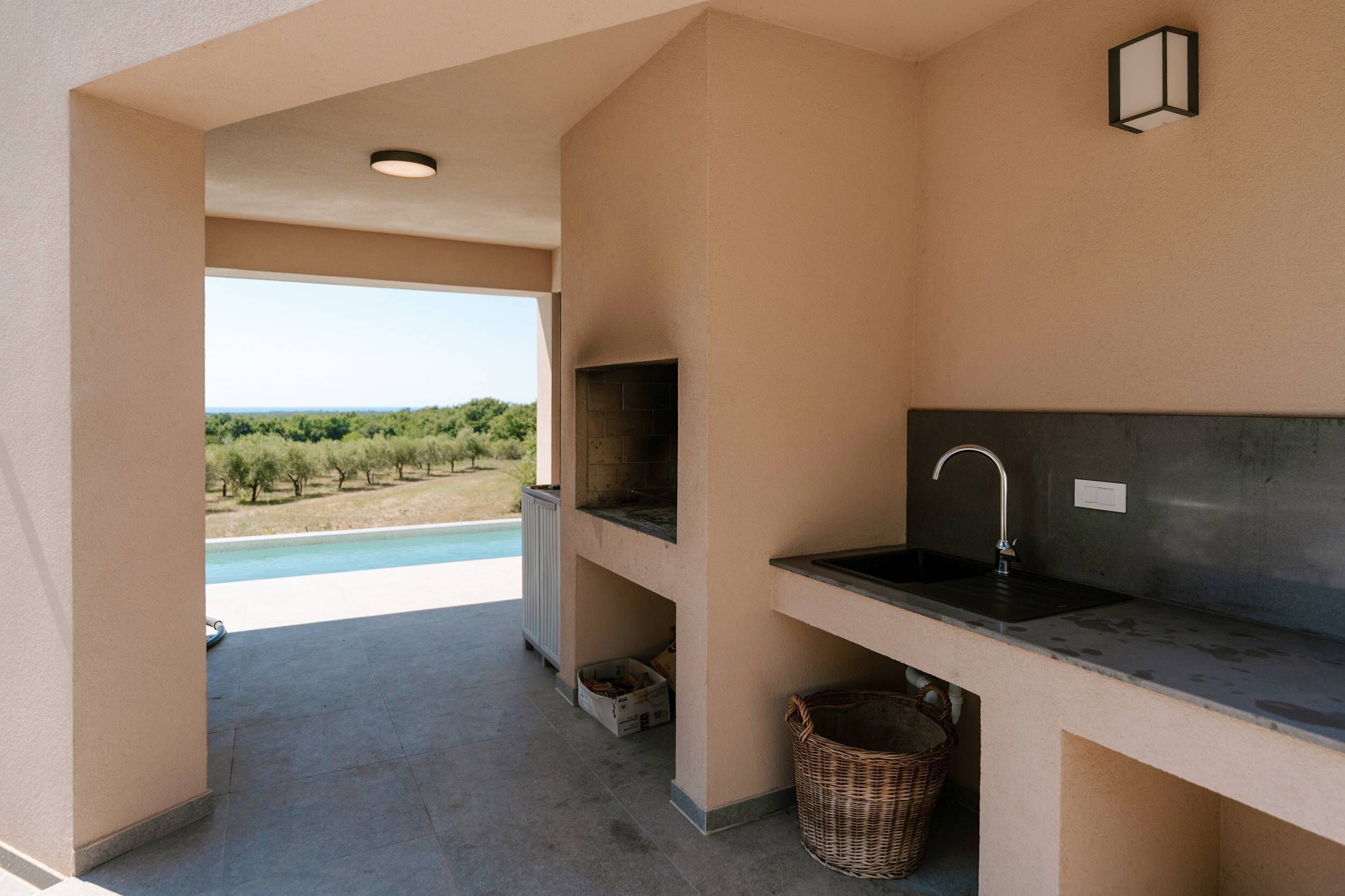 A modern kitchen with a view of a pool and vineyard.