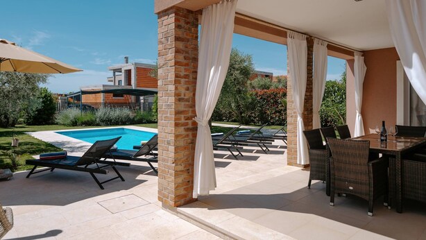 A covered outdoor area with a pool, lounge chairs, and a dining table. - Villa Mariella (100261-K1) - Kastelir (Kastelir)