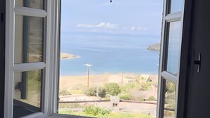 Ein Zimmer mit großem Fenster und Blick auf eine Küstenlandschaft.
