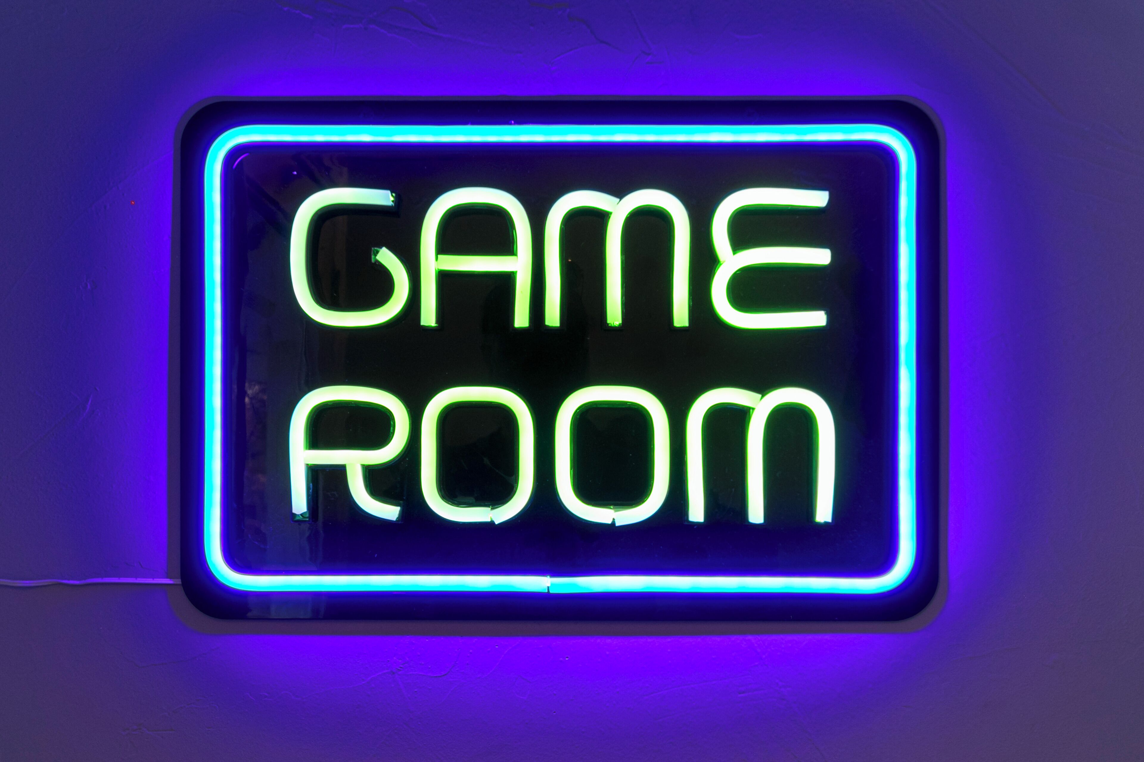 A neon sign with the words "GAME ROOM" in a rectangular frame.