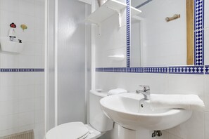 Een badkamer met toilet, wastafel en douche.