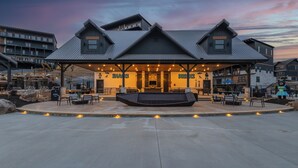 A modern building with a covered outdoor seating area, labeled "SNACKS" and "DRINKS". - MtnPlunge@SC: Pool*MtnViews*Theater*Games*Wifi*HotTub*WaterPark*FirePit (Sevierville)