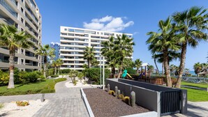 Un hôtel moderne doté d’un jardin sur le toit, de palmiers et d’une aire de jeux.