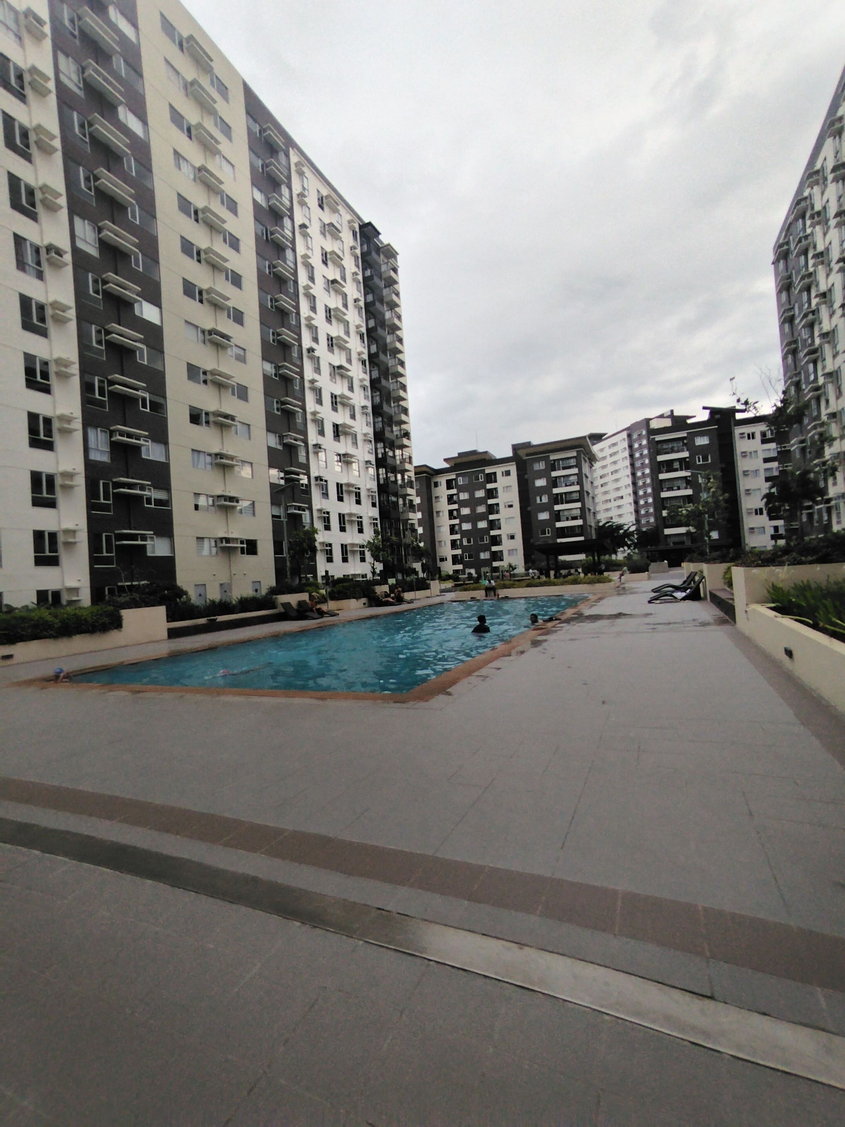 Una piscina al aire libre, sillones reclinables de piscina