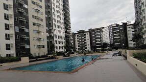 A residential building with a swimming pool. - Cozy Staycation at Avida Iloilo (Iloilo)