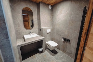 A modern bathroom with a marble floor, a wooden-framed mirror, a white sink, and a toilet. - Le Cairne Residence (La Chapelle-d'Abondance)