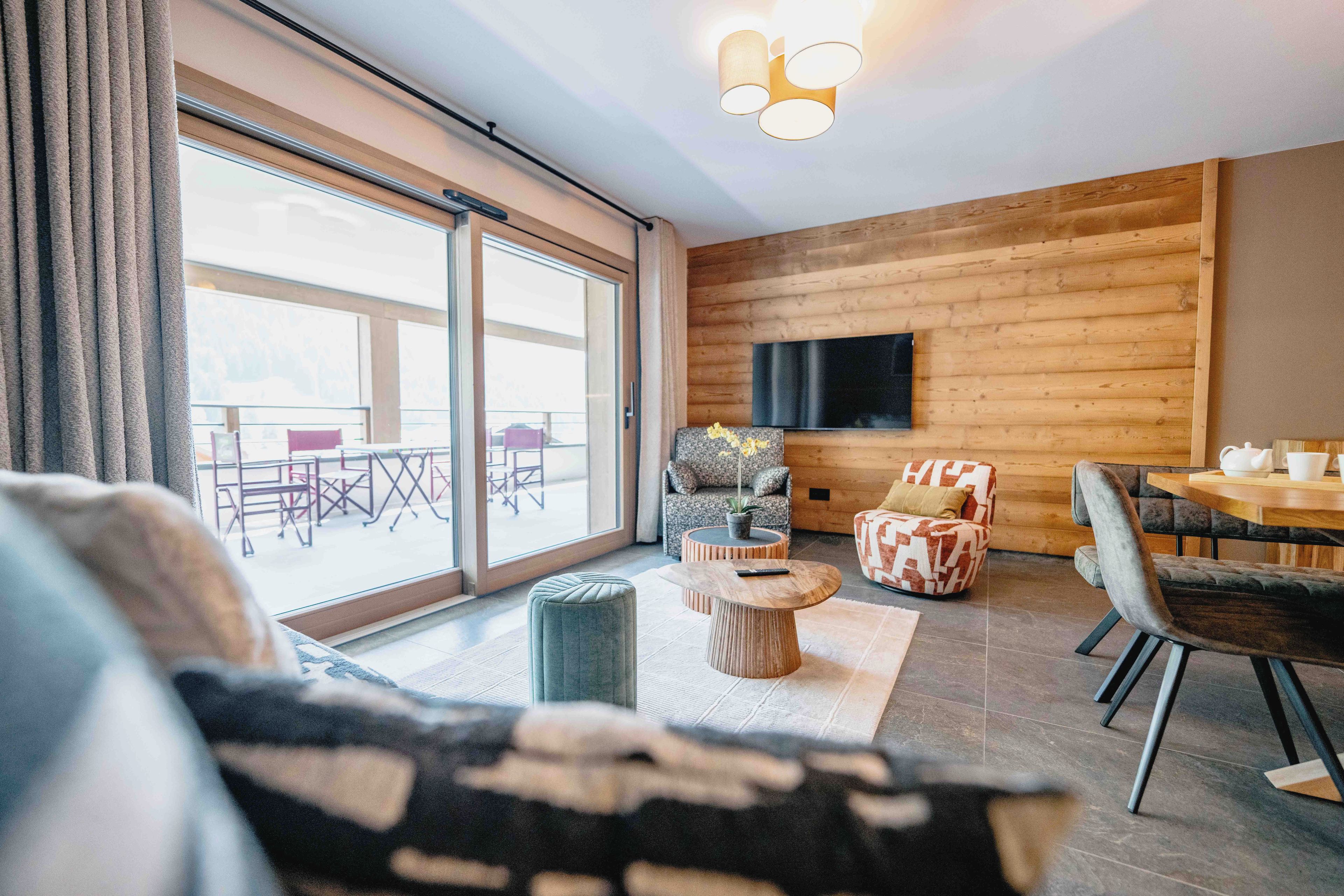 Ein modernes Wohnzimmer mit einer Couch, einem Couchtisch und einem Essbereich mit Tisch und Stühlen.