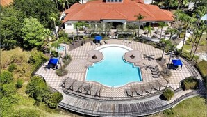 Een resort met een centraal gelegen zwembad, buitenzitplaatsen en een overdekt terras.