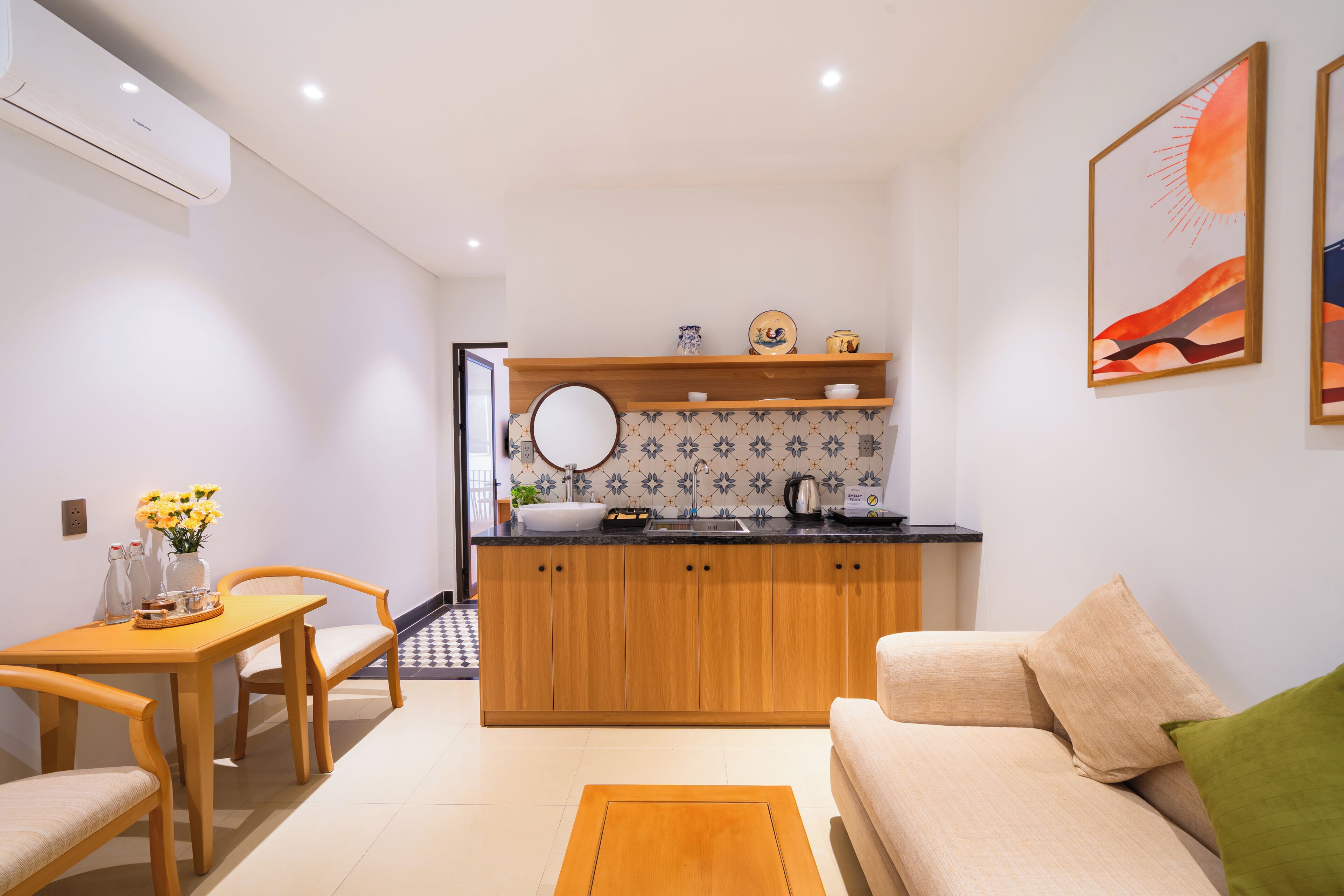 A compact living space with a kitchenette, a dining area, and a sofa.