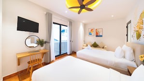 A hotel room with a bed, a desk, a chair, a TV, and a balcony with curtains. - Sujet Center Hotel by Haviland  (Da Nang)