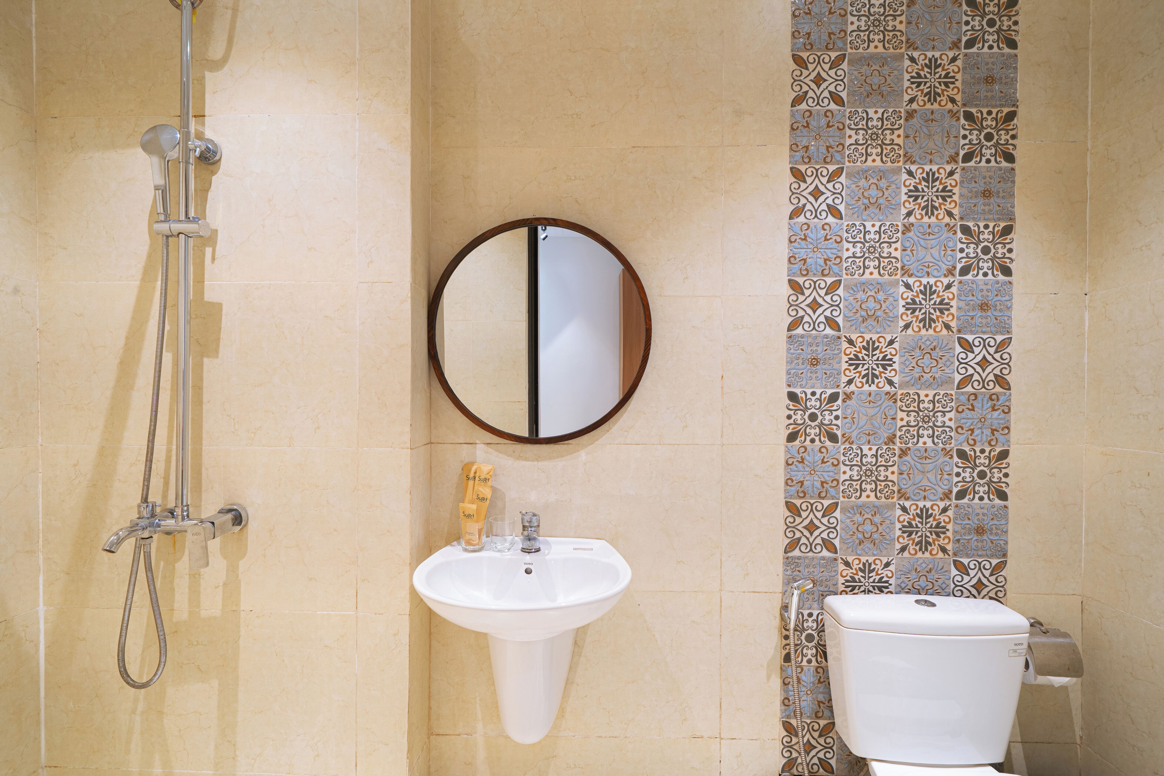 Un baño con ducha, lavabo, inodoro y espejo.