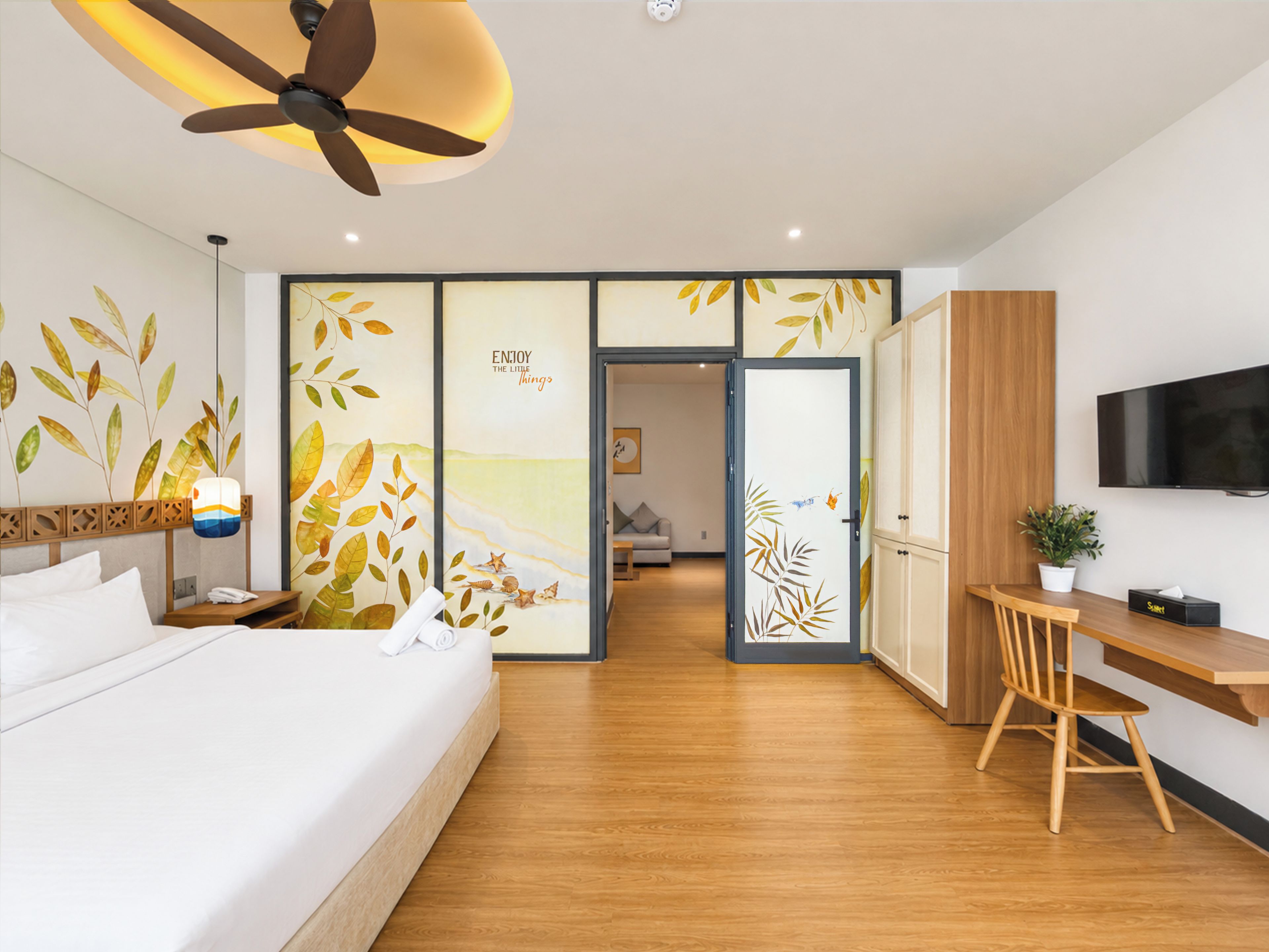 A modern hotel room with a bed, desk, and seating area.