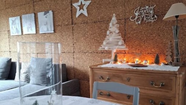 A cozy room with a corkboard wall, a small Christmas tree, and a star decoration.
