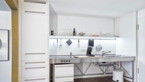 Een moderne keuken met witte kasten, een roestvrijstalen spoelbak en een inbouwoven.