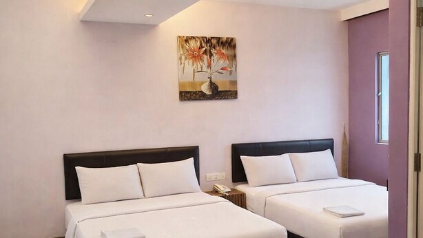 A hotel room with two beds, a sofa, a painting on the wall, and a window.