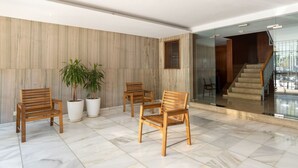A lobby with wooden chairs, potted plants, and a staircase. - Golden Hour Studio - Steps to the Sea - A/C + WiFi (Málaga)