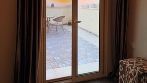 A room with a sliding glass door leading to an outdoor patio. - deluxe double room with mountain view (Al Haram Cairo)