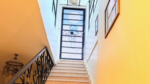 A staircase with a metal railing leading to a door with a window. - deluxe double room with mountain view (Al Haram Cairo)