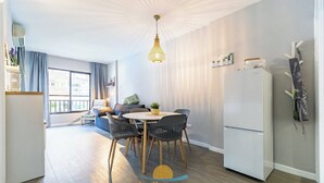 A modern kitchen with a dining area, a refrigerator, and a hanging coat rack. - 76  – Cozy Beachfront Apartment with Pool in Fuengirola (Fuengirola)