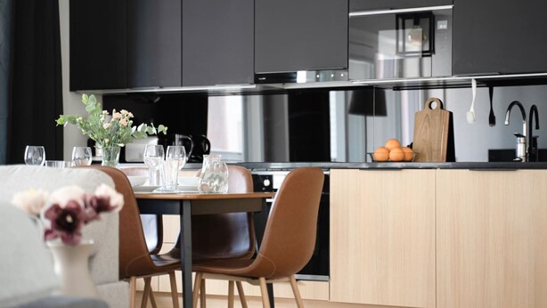Eine moderne Küche mit Essbereich, Edelstahlgeräten und Holzschränken.
