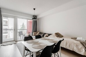 Un salon moderne comprenant un coin repas, un canapé et un balcon avec vue.