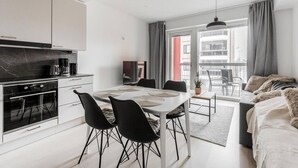 A modern kitchen with a dining area, a sofa, and a balcony with a view. - Modern studio with own glazed balcony for 3 people (Tampere)