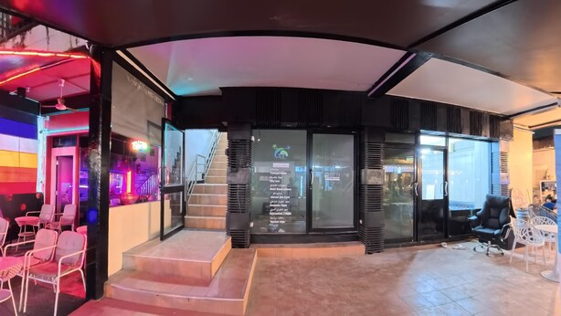 A modern hotel lobby with a staircase, seating area, and a glass door entrance. - Stay 94 Patong (Patong)