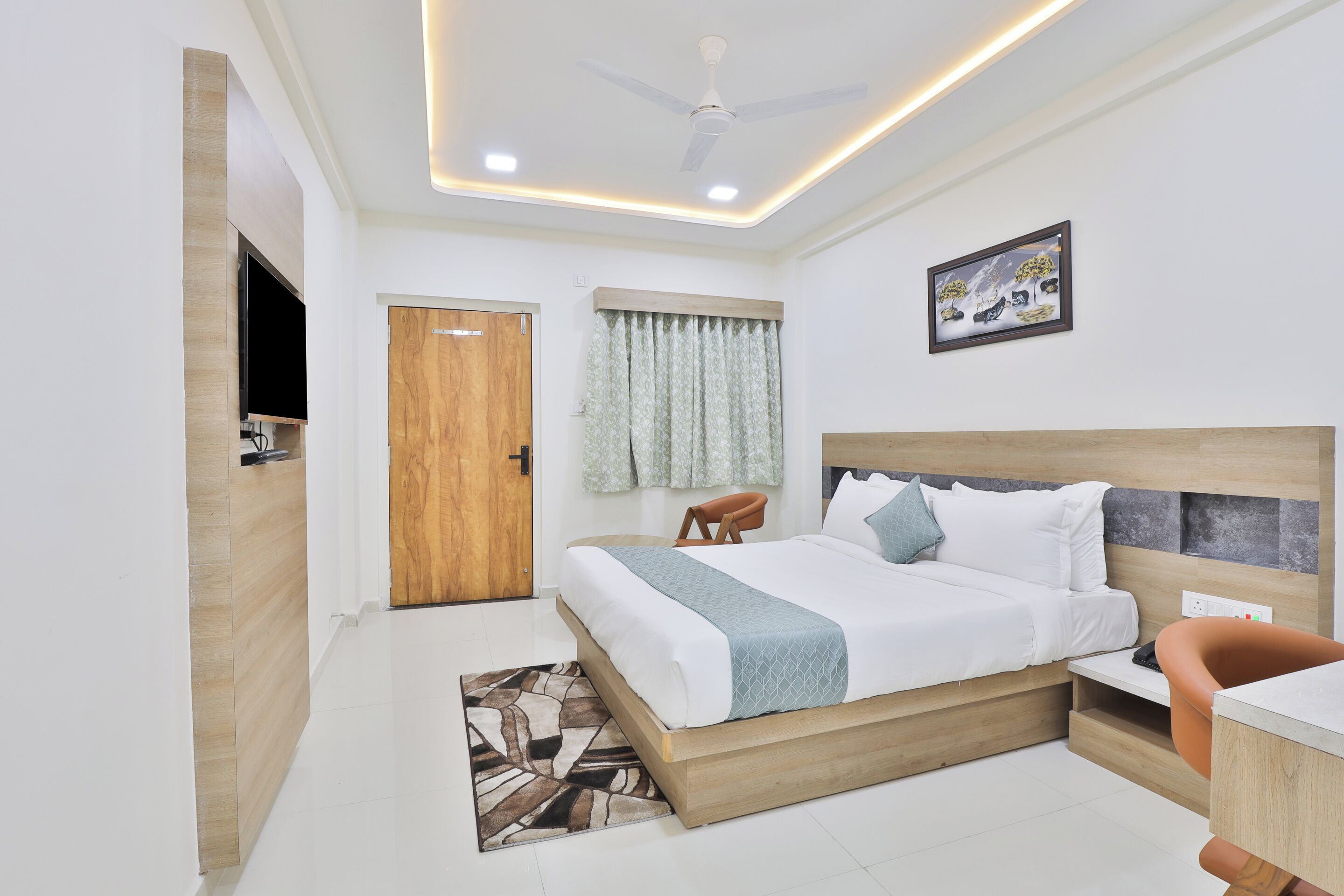 A modern bedroom with a wooden bed, a desk, and a ceiling fan.