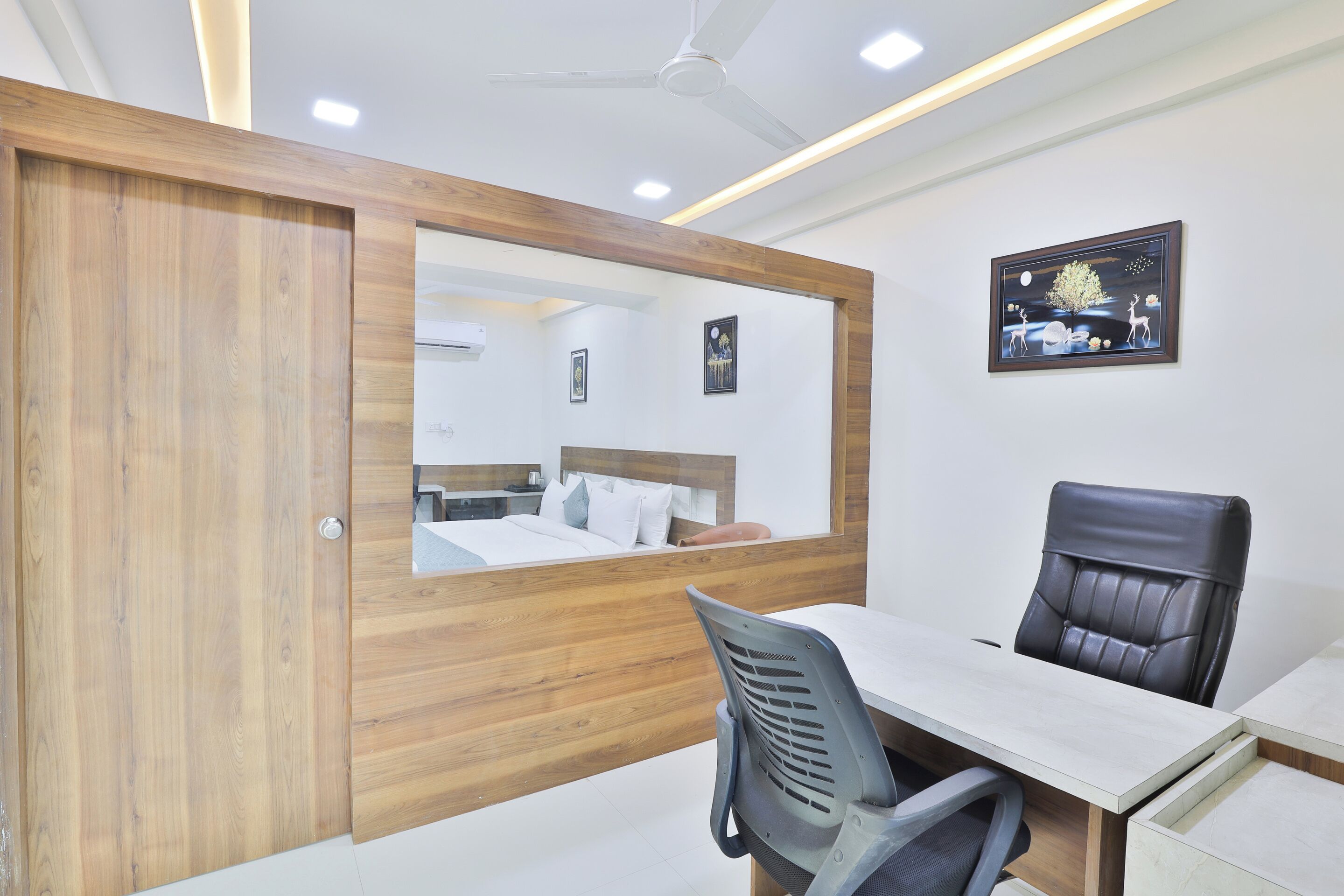 Un espacio de oficina moderno con un panel de madera, un escritorio, una silla y un ventilador de techo.