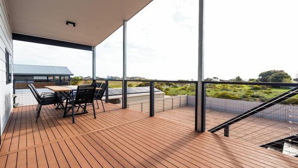A wooden deck with a table and chairs, overlooking a landscaped area. - Helios Heights - Modern 2 storey, Off Peak Special available (Moonta Bay)