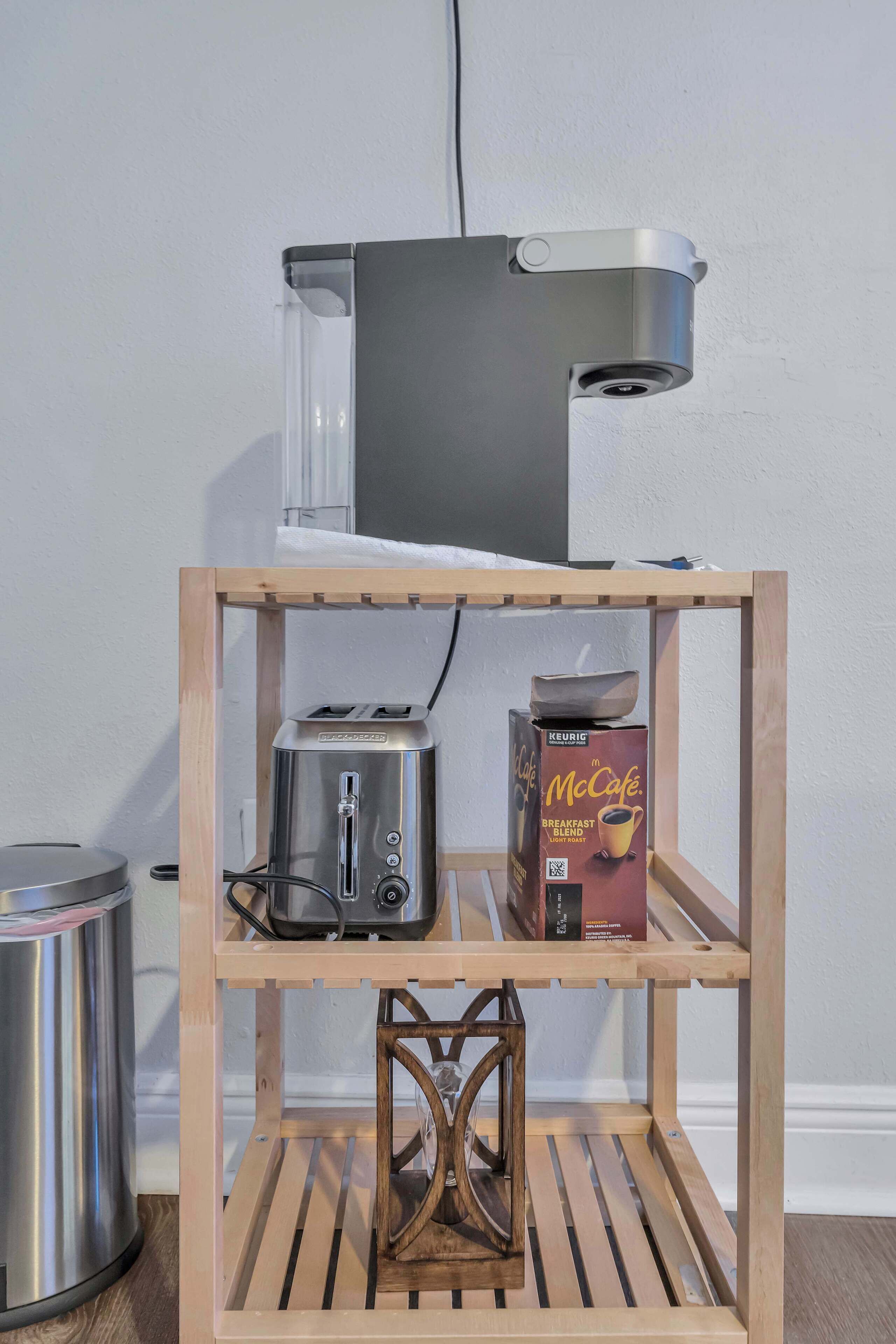 A kitchenette with a toaster, a coffee maker, and a box of McCafé coffee.