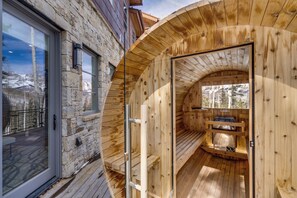 A wooden sauna with a stone exterior, a wooden deck, and a view of snow-capped mountains. - Modern Luxury - Mountain Village Chalet - Ski-In/Walk-Out - Sauna - Hot Tub (Mountain Village)