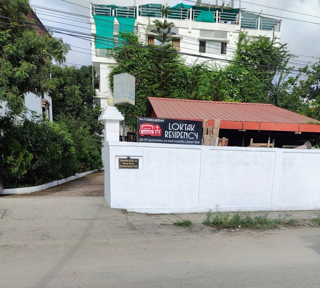 Edifício residencial com placa anunciando imóvel à venda.