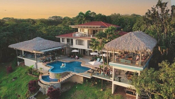 A large, multi-level house with a swimming pool, outdoor seating areas, and thatched-roof structures. - Villa Marala (Parrita)