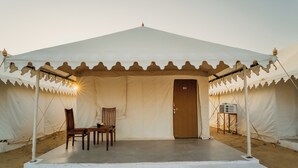 A tent with a door, two chairs, and a small table. - Shreeji Desert Resort (Sam)