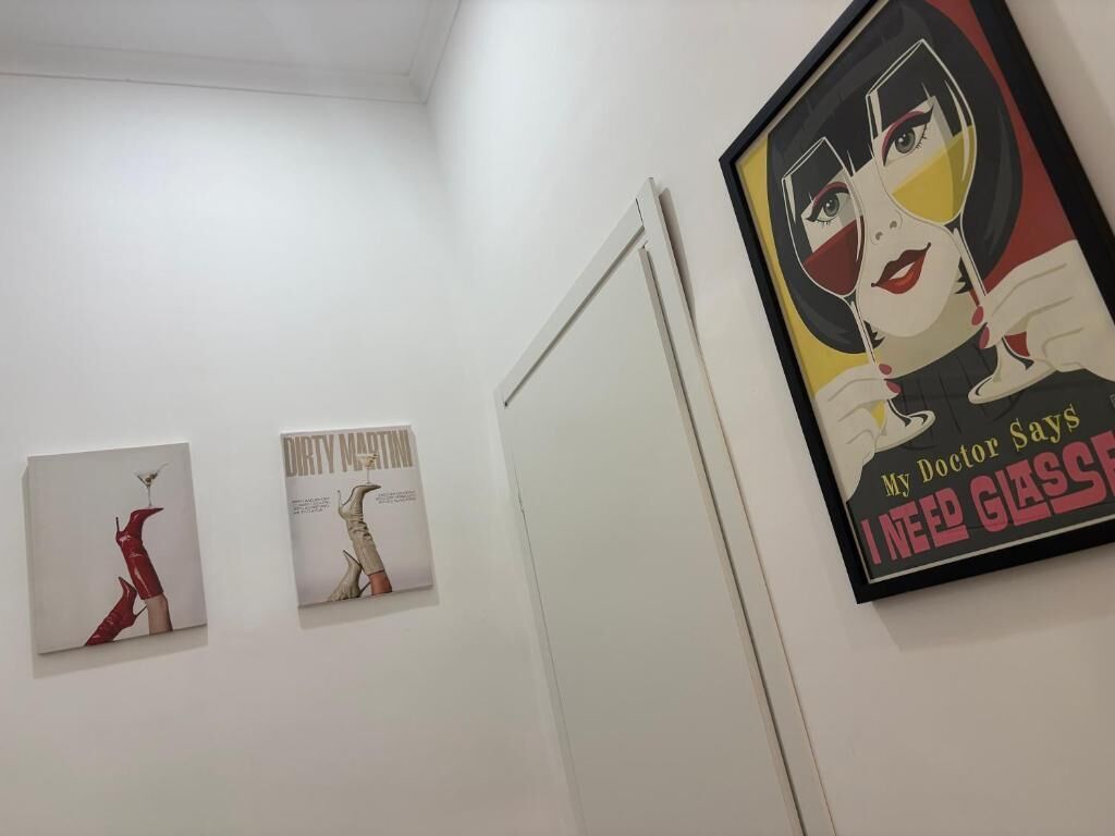 A wall with three framed artworks and a door.