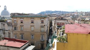 A narrow urban street with buildings, including a yellow building with a red roof and a white dome structure. - B&B Napoli Tonic (Naples)