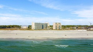 A beachfront hotel with multiple buildings, a sandy beach, and ocean waves. - Renovated Beach Front Ocean View Condo TOG 723 (Panama City Beach)