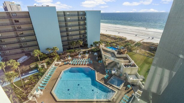 Ein Hotel mit Pool, Meerblick und mehreren Etagen.