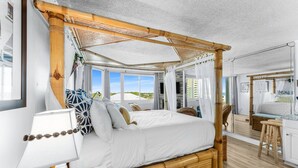 A room with a large bed, a bedside table, a lamp, and a view of the outside. - Top of the Gulf 620 Beachfront Couples Retreat (Panama City Beach)