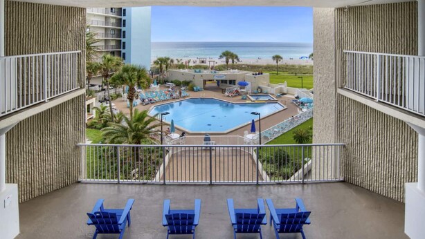 A pool area with multiple lounge chairs and a view of the ocean. - Top of the Gulf 620 Beachfront Couples Retreat (Panama City Beach)