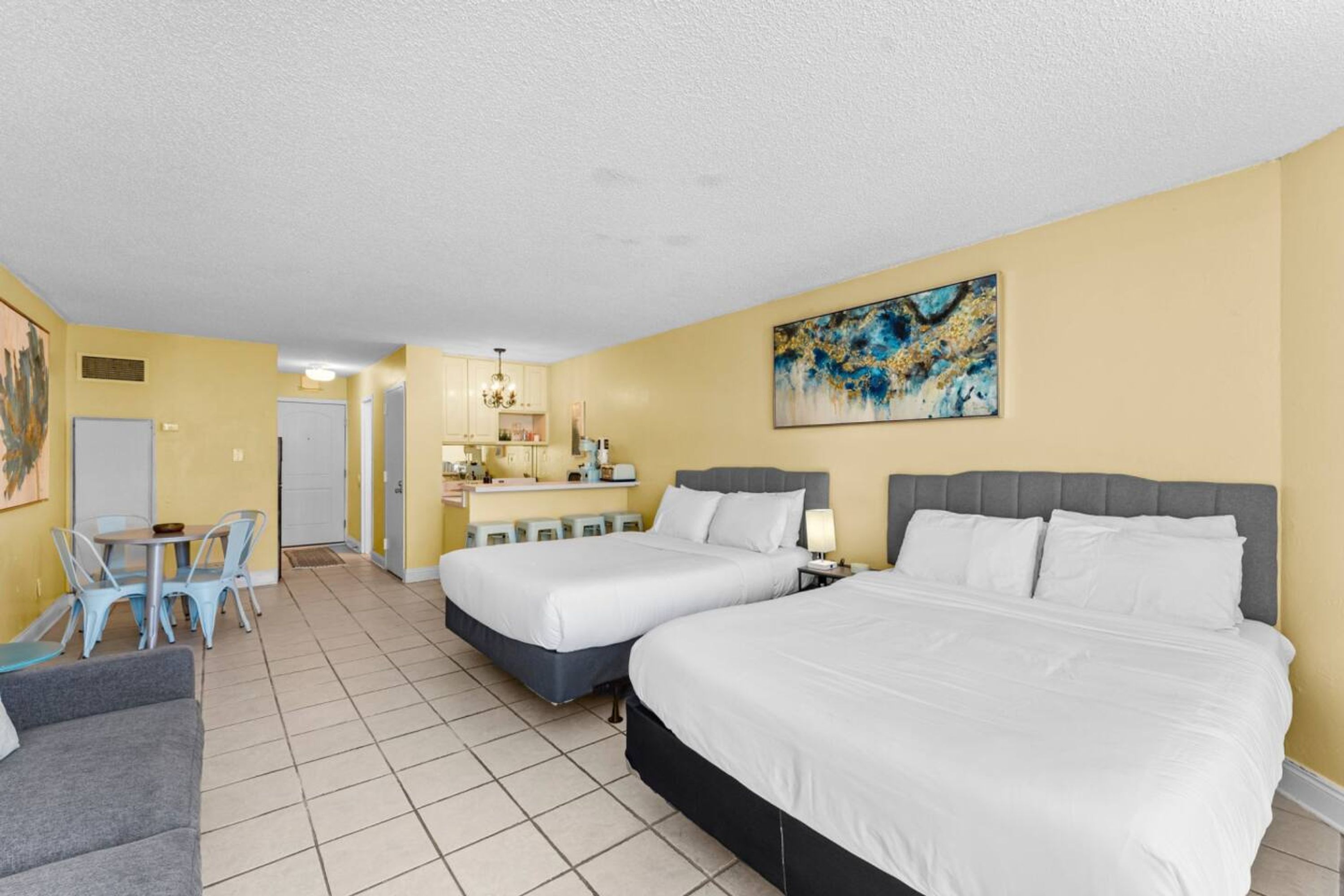 Une chambre d’hôtel avec deux lits, un coin repas et une kitchenette.