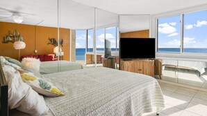 A bedroom with a large bed, a TV, and a view of the ocean. - Top of the Gulf 421 - Luxury Beach View Condo (Panama City Beach)