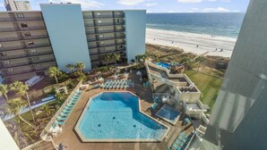 A hotel with a pool, beach view, and multiple floors.