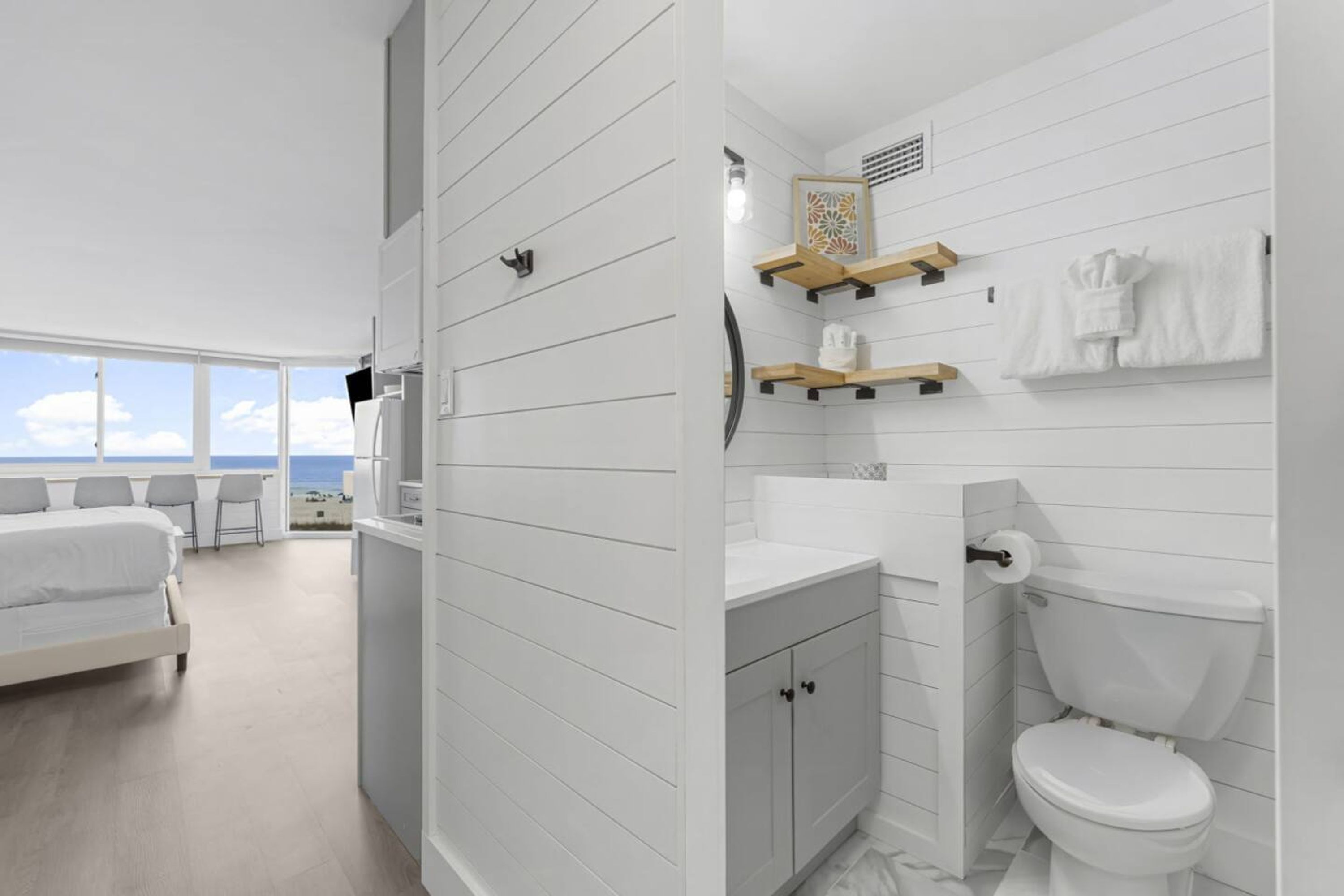 Ein modernes Badezimmer mit Toilette, Waschbecken und Holzregalen.