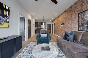 Un salon moderne avec un canapé, une table basse et un mur en briques.
